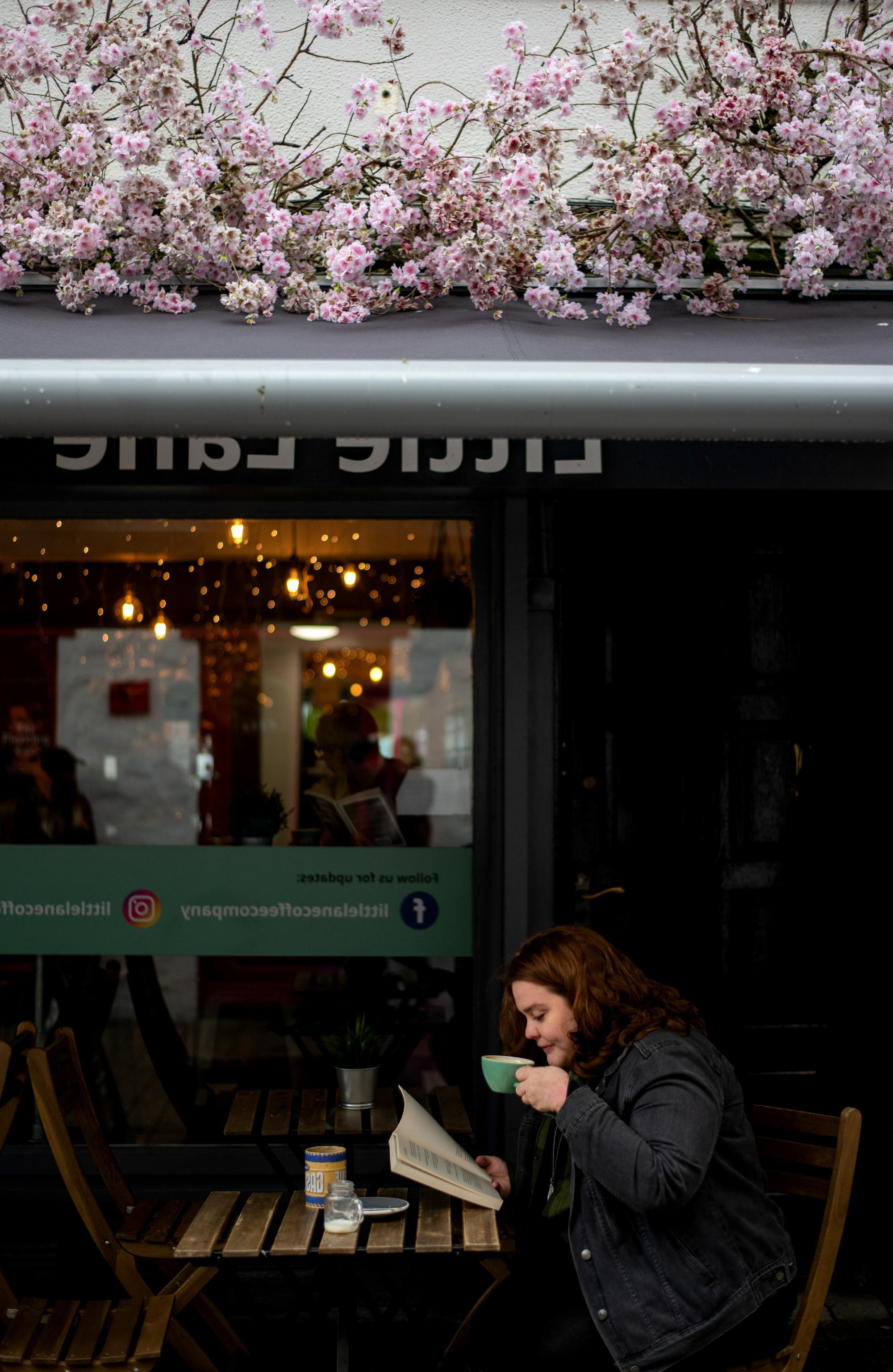 young woman sips coffee at a cafe in Ireland